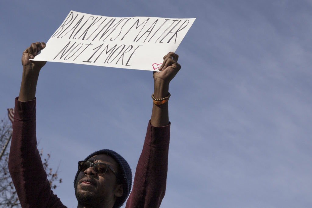 Protester raising "Black Lives Matter" sign